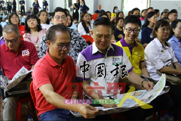 刘志俍（左起）与林钦为一起阅读《中国报》。左3及左4为陈文松及邓艾琳。