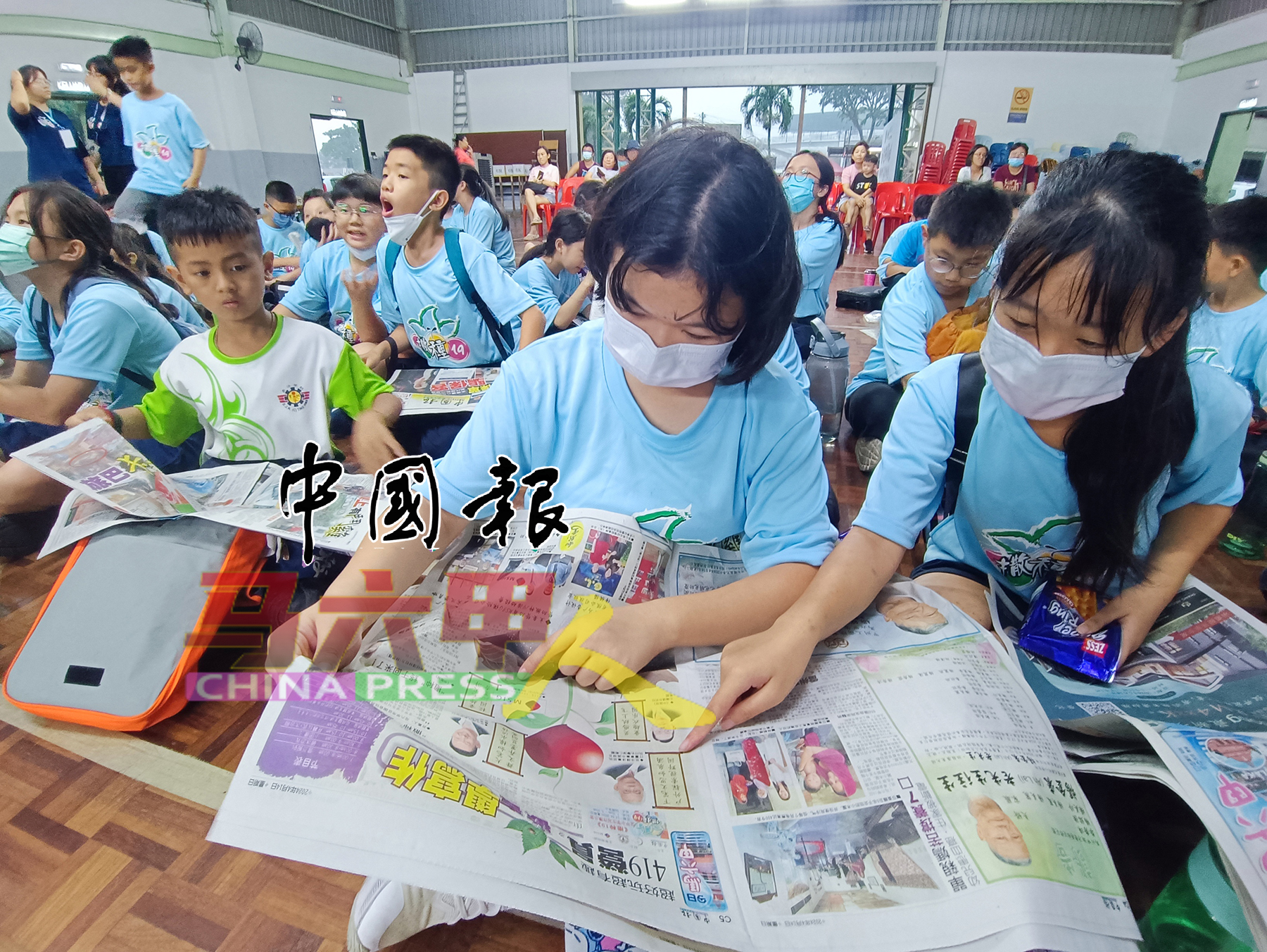 ■小学生们一起阅读《中国报》。