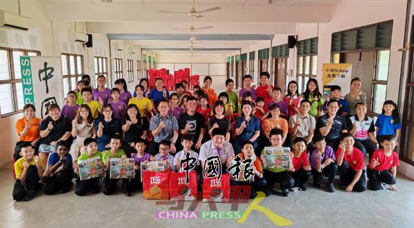 有奖问答得奖学生戴宇琛（前排左6起）、廖佑伟、吴俞漮及受惠学生，举起手中的《中国报》，与嘉宾们合照。