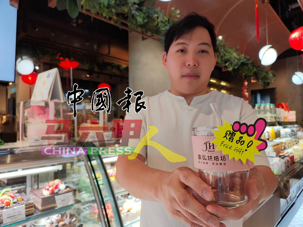 傅家弘展示精美玻璃杯，此乃回馈予购买母亲节系列蛋糕的顾客之赠品。