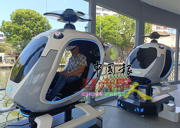 刘志俍体验直升机虚拟实境游戏。