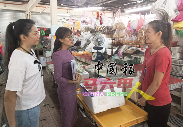 骆慧茹（左2）向菜贩陈小姐了解巴刹设施的问题，左为居民张小姐。