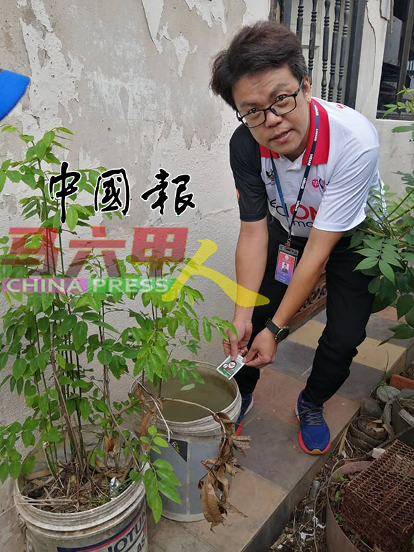 ■李春沅把灭蚊药洒在水中。