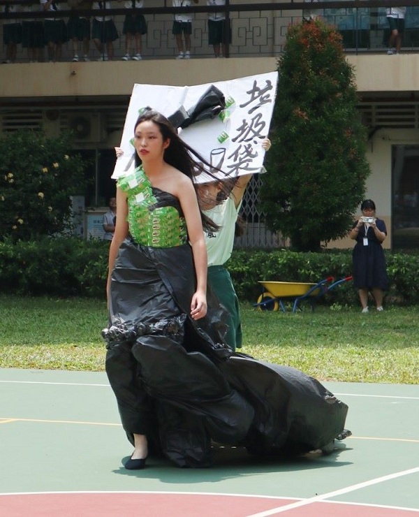 学生穿上用垃圾袋及包装纸制成的“衣服“。