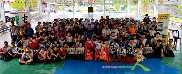 ■有奖问答得奖学生及受惠学生举起手中的《中国报》，与嘉宾们合照。