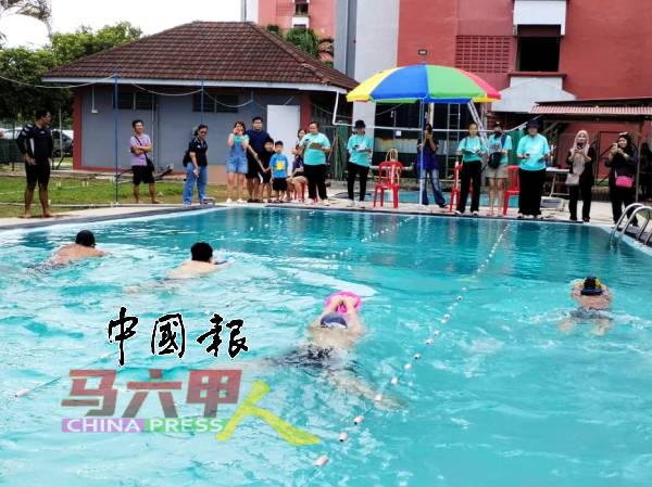 特殊孩子第一次参加游泳赛，家长们在泳池旁为他们加油打气。