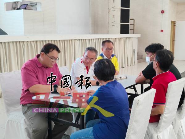 叶进强（面向镜头者左）一对一会见面对申请公民权问题的人士，并给予谘询。