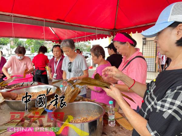 大姐大婶一起动手裹肉粽。