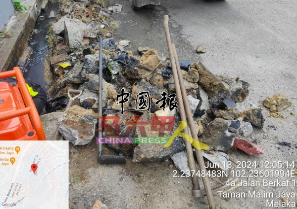 工人清理柏卡1路早前塌陷掉在沟中的沟堤石块。(图邓永森提供)