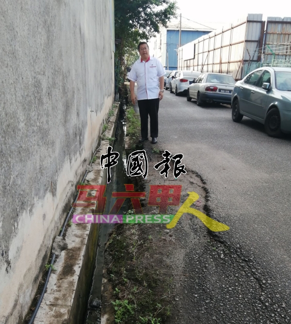 邓永森勘察横巷的凹陷路面和崩塌水沟。