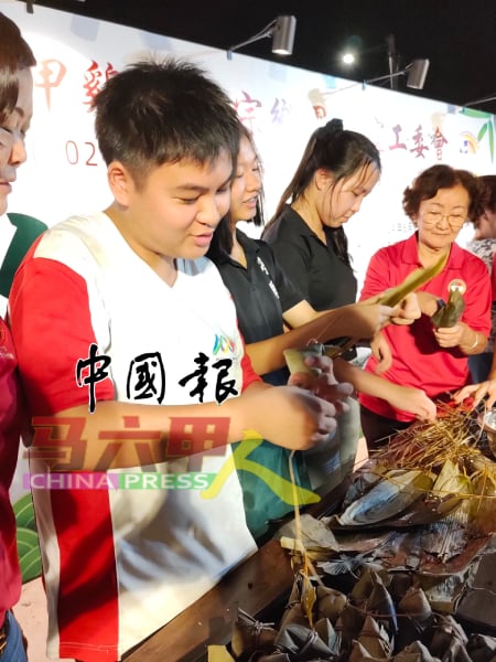 男生学习裹粽，一点也不马虎。