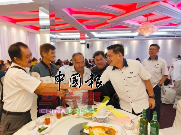 林万锋（右） 与党员们握手寒暄。