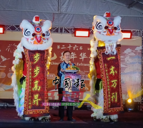 黄运强教授接领舞狮采青的福品。