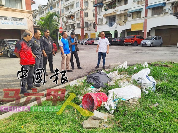 业主装修后把建筑废料丢在草场上。右是刘志俍。