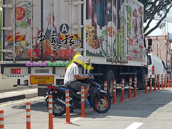 摩哆骑士不愿被堵在重型车后方等待，宁愿冒险逆向行驶。