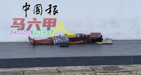 ■交通川流不息，环境嘈杂的街上，其中一名流浪汉似肚依旧睡得香甜。