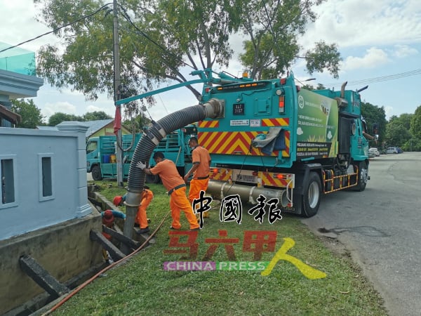 南方环保公司清洁工人清理水沟，避免出现沟水排流受阻而滋生蚊虫。（档案照）