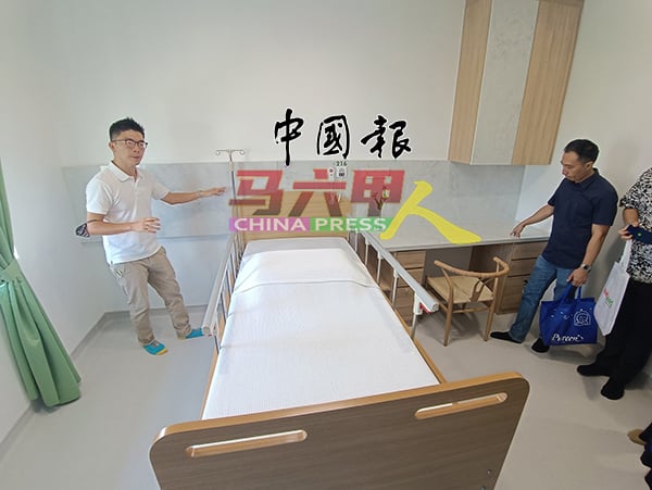 林志明（左）向来宾们展示各种房间类型。