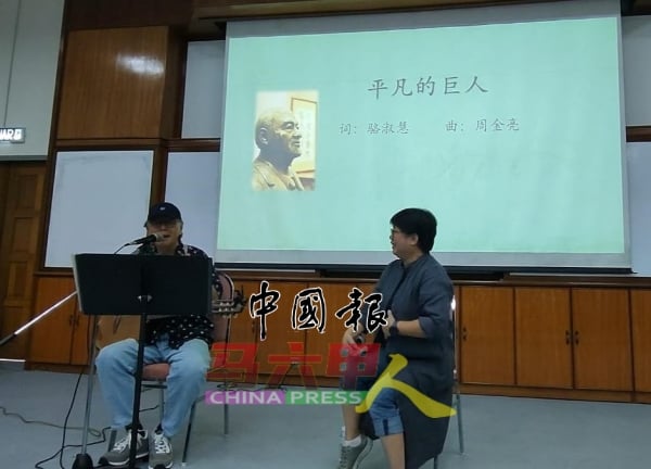 周金亮（左）演唱由骆淑慧（右）作词的《平凡的巨人》。