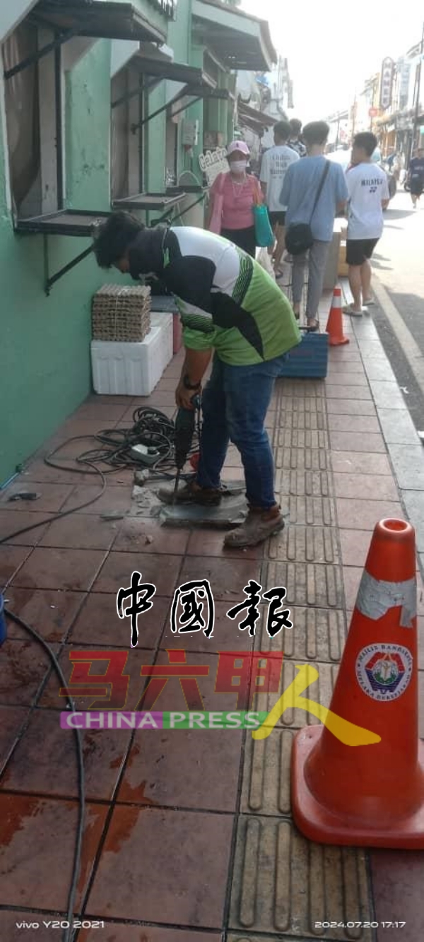 甲历史城市政厅派员铲除留在走道的灯柱基座。