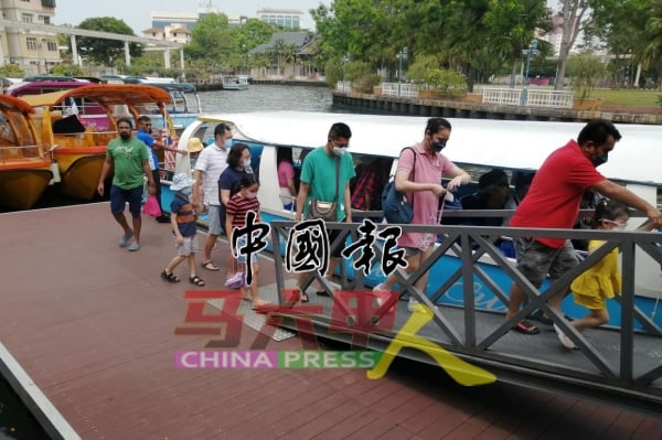 一些游客外出旅游时依然会做好防疫工作，图为带口罩的游客乘船后下船离开。