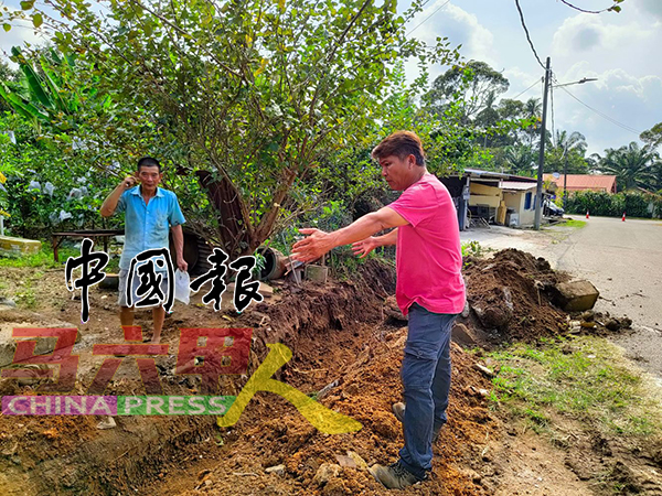 村民对沟渠提升问题存有疑惑，余建南（右）给予解释。