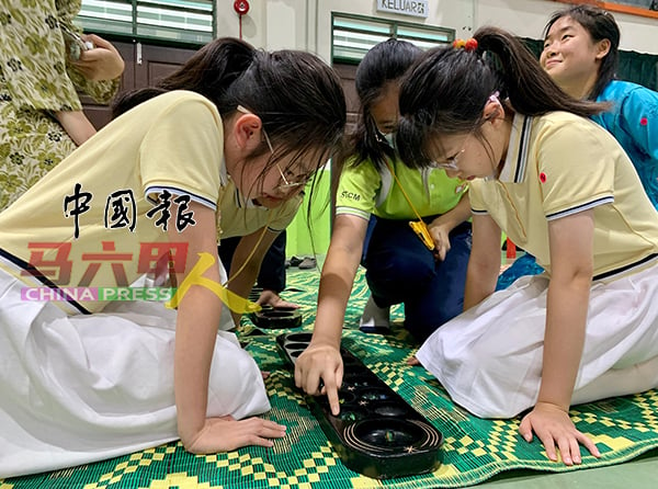 ■中国学生学习玩马来播棋。