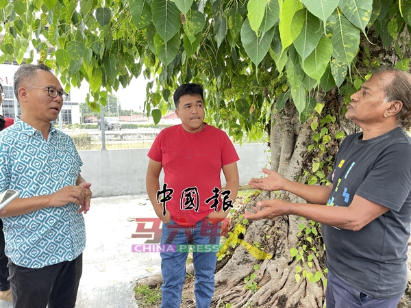 拉惹占（右）向刘志俍（左）倾诉遭受水灾之苦。中为吉瓦。