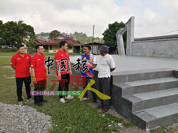 郑瑾韩（左起）、黎健祥和郭子毅，向居民讲解草场提升工程进展。