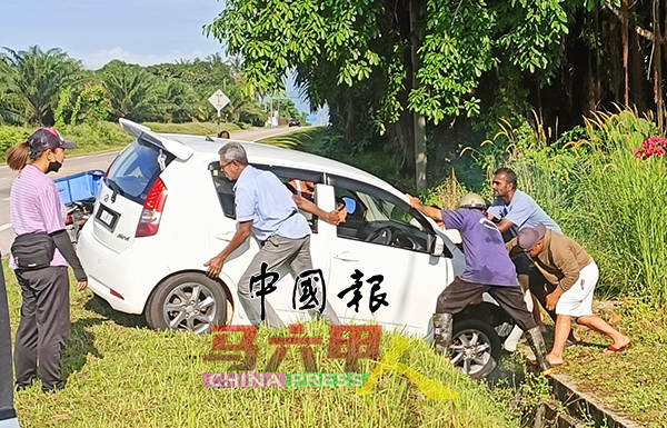 ■村民及路过行人合力将陷沟车子推起，显现各族守望相助精神。