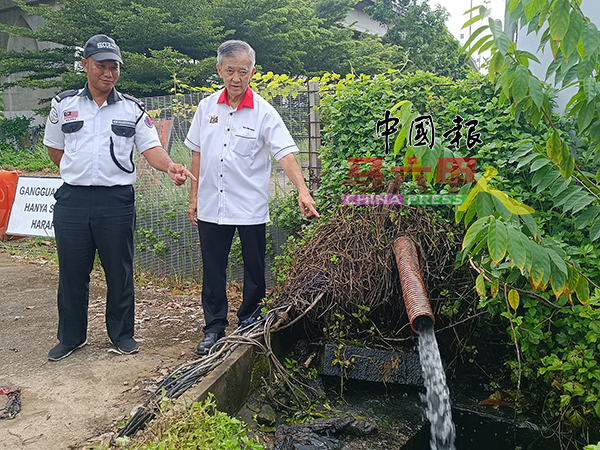 ■陈劲源（右）向有关建筑工地的守卫了解情况后，澄清有关水管流出的水实则是该建筑工地排放泊车场的积水。