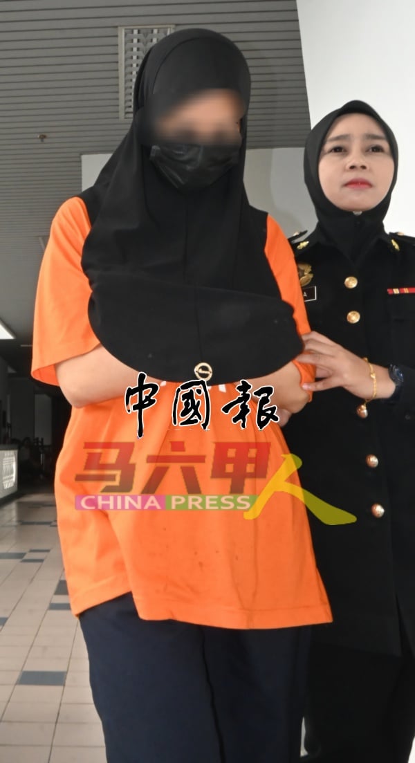 反贪会官员把女嫌犯（左）押上法庭申请延扣。