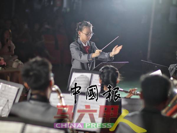 学生指挥专注投入，手势引领着管乐团奏出动人旋律。