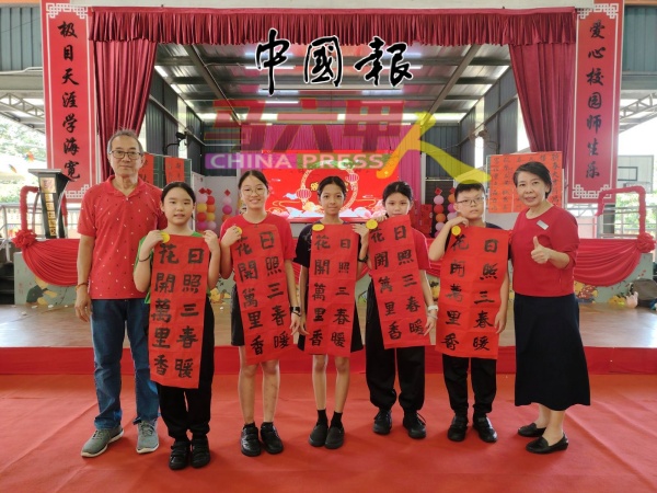 林敬富(左)在曾慧云(右)陪同下,颁奖给五年级挥春比赛得奖的同学,左2起陈柔蒽、陈欢欣、郑奕绚、廖莉恩及陈念奕。