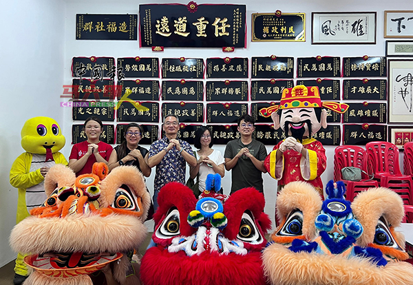 邱培栋（中）与媒体向公众贺年。左为王欣怡。