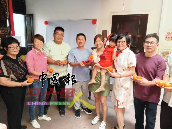 吴槿坤(左4)派红包和年柑给会员。