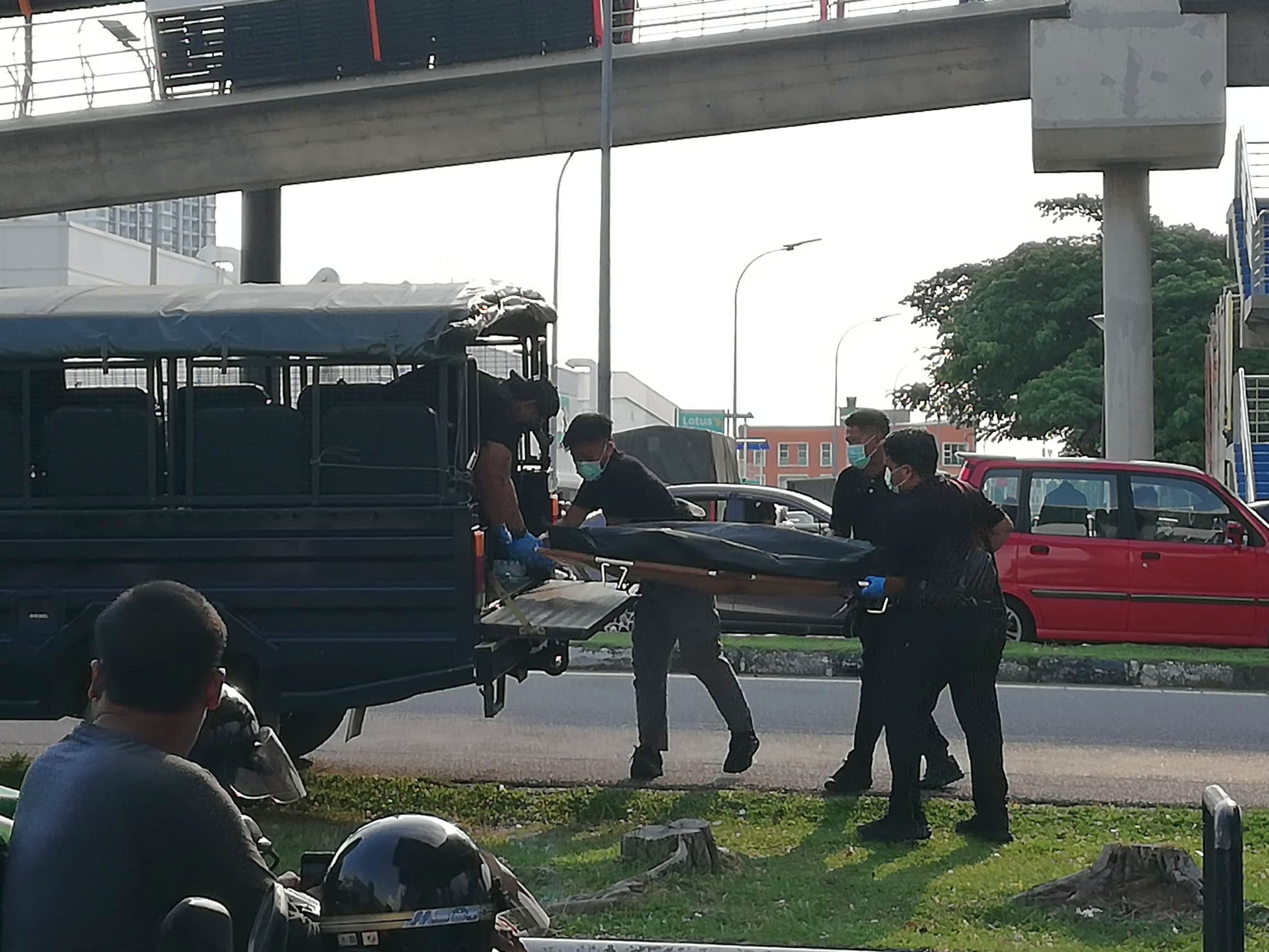 警员把遗体抬上警车。