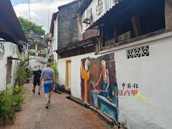 ■游客漫步在后巷参观壁画，有另一番旅游体验。
