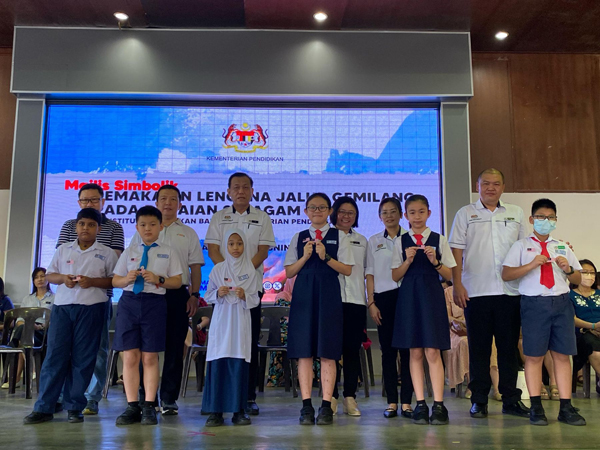 佩戴国旗扣章的各族学生，与校方及家协代表合照，同时也展现马来西亚多元族群与和谐社会。