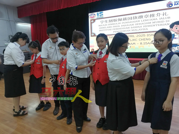 副校长梁桂仪（左起）、副校长尤凯文、郑敏莉、副校长林俏蓁，为学生载上国旗徽章。