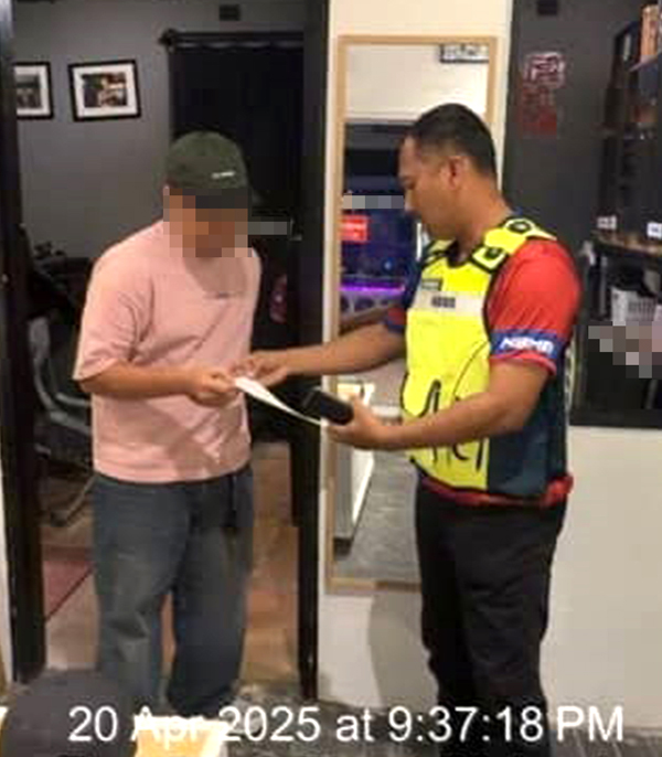 ■马六甲历史城市政厅执法员向服装设计店主发出罚单。