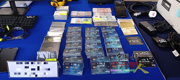 警方在行动中起获227张复制转账卡、令吉、新币和复制机等。