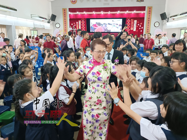 郑敏莉校长与学生们击掌祝福,场面温馨。