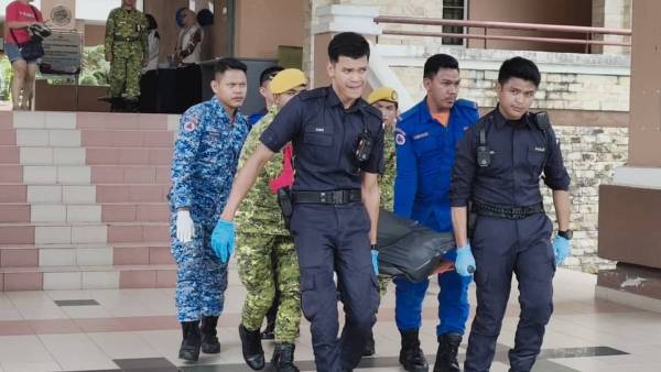 警员、民防人员和警卫团员，合力把遗体抬离现场。
