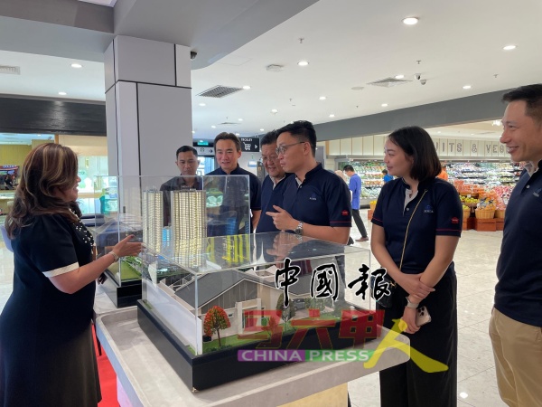 吴俊豪（右3起）及郑祖翰等，参观展销会参展摊位。