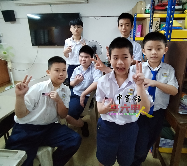学生们开心地展示国旗扣章。