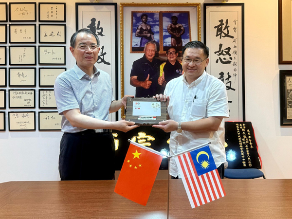■颜天禄(右起)赠送纪念品给杨根平。