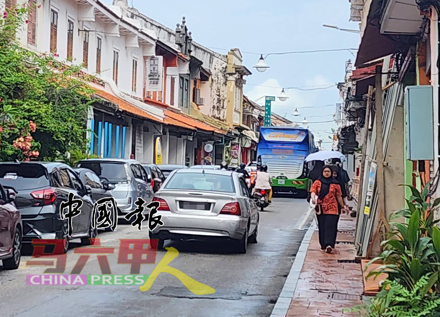 老街区仍有重型车辆，如旅游巴士穿梭。