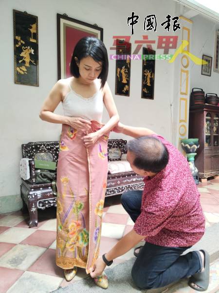 陈再政与郑瑞玲示范正确的穿戴纱笼方法。
