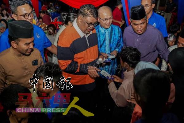 甲首长（前排左2）派发青包给出席的小朋友，与民同乐，右2为魏喜森。